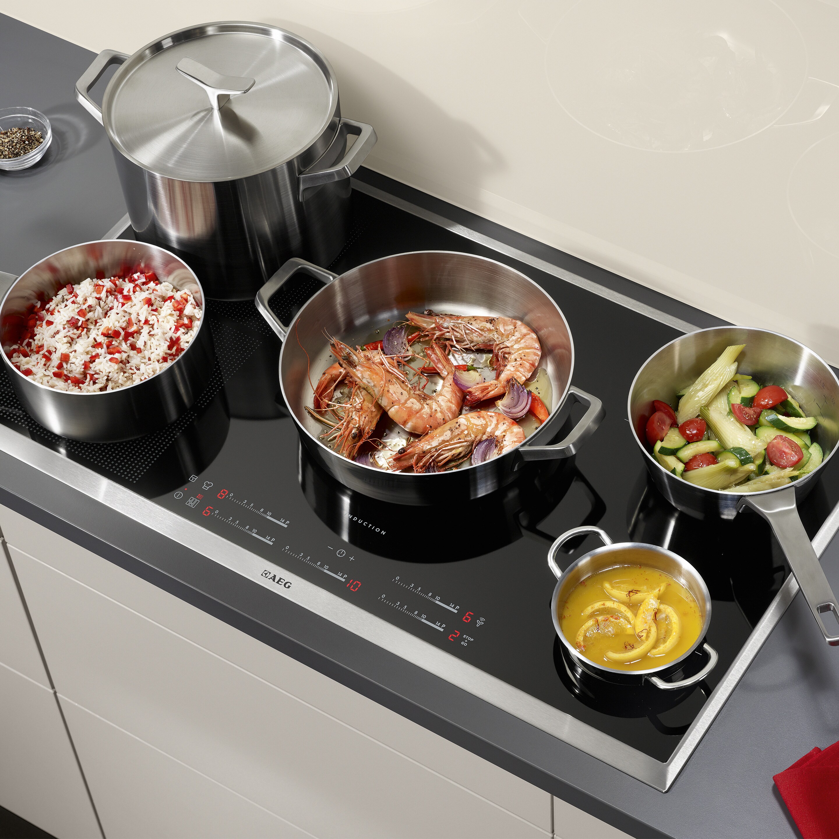 Indukcijska ploča Electrolux korištena za pripremu različite hrane u tavama