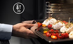 Person taking out baking tray from oven